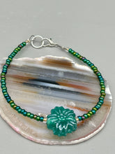 Load image into Gallery viewer, This blue-green pressed glass floral beaded bracelet is a nature-inspired accessory that adds a hint of summer to any look. Crafted with intricate green-blue pressed glass beads and metal wire, the bracelet has an iridescent shimmer finish and a lobster claw clasp for secure wear. Perfect for day-to-night looks.  Measurements:  Bracelet: 8 1/2" in length