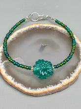 Load image into Gallery viewer, This blue-green pressed glass floral beaded bracelet is a nature-inspired accessory that adds a hint of summer to any look. Crafted with intricate green-blue pressed glass beads and metal wire, the bracelet has an iridescent shimmer finish and a lobster claw clasp for secure wear. Perfect for day-to-night looks.  Measurements:  Bracelet: 8 1/2" in length