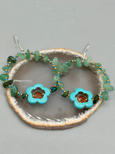 Load image into Gallery viewer, This pair of earrings features a turquoise magnesite floral bead with a vibrant orange glass bead and natural green aventurine stone chips juxtaposed against gold and blue glass beads. Measurements: 2" length