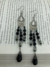 Load image into Gallery viewer, This stylish three-strand black and silver glass beaded earring design presents a beautiful dancing effect, boasting a large black teardrop glass bead. A versatile accessory, it suits a variety of ensembles from cocktail chic to wedding fineries, and its minimalist aesthetic lends a modern charm.  Measurements: 3 3/4” in length