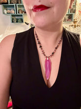 Load image into Gallery viewer, Unlock your inner goddess with this stunning Large Fuchsia Agate Geode Sliced Stone Chip Necklace. Featuring a vibrant fuchsia agate geode pendant surrounded by Rhodonite stone chips and gold and black glass beading, the silver leaf bail completes this chic and boho-inspired look. Make a bold statement with this bohemian-style gemstone necklace. Measurements: Necklace is 17 3/4” in length - pendant is 3” Height