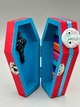 Load image into Gallery viewer, Coffin keepsake box represents the eternal love for a special kitty cat in your life. Cat silhouette sitting admiring the moon and stars. Day Of The Dead art was created for the cat lovers who adore their sweet kitty. Coffin-shaped box features a bright and vibrant red exterior, with an adoring yellow crescent moon and star. Complemented with a shimmery blue ribbon and smiling moon, the inside is painted in a bright bluer hue with black floral cross and detailing a traditional Mexican-themed fabric.