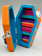 Load image into Gallery viewer, Coffin keepsake box represents the eternal love for a special kitty cat in your life. Cat silhouette sitting admiring the moon and stars. Day Of The Dead art was created for the cat lovers who adore their sweet kitty. Coffin-shaped box features a bright and vibrant orange exterior, with an adoring blue crescent moon and yellow star. Complemented with a shimmery blue ribbon and smiling moon, the inside is painted in a bright blue hue with black floral cross and detailing a traditional Mexican-themed fabric.