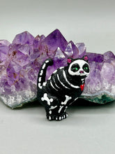 Load image into Gallery viewer, This hand-crafted art magnet featuring a skeleton cat is the ideal home decor for cat lovers, Halloween or Day Of The Dead enthusiasts. Perfect for adorning fridges, lockers, cubicles, and toolboxes.   I wanted to create an art piece that represented the eternal love for a special kitty cat in your life. Add a little touch of Mexican art to your home or office. This Day Of The Dead art was created for the cat lovers who adore their sweet kitty. H 2” x W 1/2” x D 3/8”