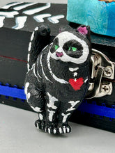 Load image into Gallery viewer, This hand-crafted art magnet featuring a skeleton cat is the ideal home decor for cat lovers, Halloween or Day Of The Dead enthusiasts. Perfect for adorning fridges, lockers, cubicles, and toolboxes.   I wanted to create an art piece that represented the eternal love for a special kitty cat in your life. Add a little touch of Mexican art to your home or office. This Day Of The Dead art was created for the cat lovers who adore their sweet kitty. H 2” x W 1/2” x D 3/8”