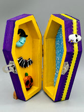 Load image into Gallery viewer, Coffin shaped box features a Day of the Dead kitty cat wearing a cute witchy hat while standing next to her witchy broom and a flying bat friend. The inside of the coffin is adorned with a witchy crescent moon, Jack-O-Lantern and a cute bat. This captivating coffin box makes an eye-catching, bewitching and whimsical Halloween-themed art piece that adds a one-of-a-kind Halloween touch to any home or office. L: 4 7/8"; W: 3"; H: 1 1/2"