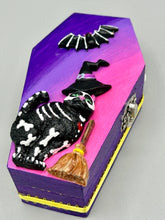 Load image into Gallery viewer, Coffin shaped box features a Day of the Dead kitty cat wearing a cute witchy hat while standing next to her witchy broom and a flying bat friend. The inside of the coffin is adorned with a witchy crescent moon, Jack-O-Lantern and a cute bat. This captivating coffin box makes an eye-catching, bewitching and whimsical Halloween-themed art piece that adds a one-of-a-kind Halloween touch to any home or office. L: 4 7/8"; W: 3"; H: 1 1/2"