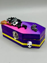 Load image into Gallery viewer, Coffin shaped box features a Day of the Dead kitty cat wearing a cute witchy hat while standing next to her witchy broom and a flying bat friend. The inside of the coffin is adorned with a witchy crescent moon, Jack-O-Lantern and a cute bat. This captivating coffin box makes an eye-catching, bewitching and whimsical Halloween-themed art piece that adds a one-of-a-kind Halloween touch to any home or office. L: 4 7/8"; W: 3"; H: 1 1/2"