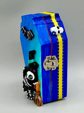 Load image into Gallery viewer, Coffin shaped box features a Day of the Dead kitty cat wearing a cute witchy hat while standing next to her witchy broom and her flying bat friend. The inside of the coffin is adorned with a witchy crescent moon, Jack-O-Lantern and a cute Day of the Dead tiny kitten. This captivating coffin box makes an eye-catching, bewitching and whimsical Halloween-themed art piece that adds a one-of-a-kind Halloween touch to any home or office.