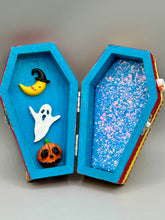 Load image into Gallery viewer, Coffin shaped box features a Day of the Dead kitty cat wearing a cute witchy hat while standing next to her witchy broom and her flying bat friend. The inside of the coffin is adorned with a witchy crescent moon, Jack-O-Lantern and a cute bat. This captivating coffin box makes an eye-catching, bewitching and whimsical Halloween-themed art piece that adds a one-of-a-kind Halloween touch to any home or office.
