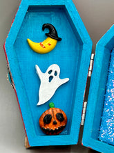 Load image into Gallery viewer, Coffin shaped box features a Day of the Dead kitty cat wearing a cute witchy hat while standing next to her witchy broom and her flying bat friend. The inside of the coffin is adorned with a witchy crescent moon, Jack-O-Lantern and a cute bat. This captivating coffin box makes an eye-catching, bewitching and whimsical Halloween-themed art piece that adds a one-of-a-kind Halloween touch to any home or office.