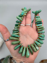 Load image into Gallery viewer, This striking Extra Large Turquoise Stone Beaded Necklace With Brass Finish Metal Beads instantly adds a touch of luxury to any outfit. Beautifully crafted with an alluring blend of extra large turquoise stone beads and brass finish metal beads, this distinctive necklace invokes an elegant cascade of vibrant color.    Measurements:    Necklace is 21 1/2 " in length adjustable to 23"