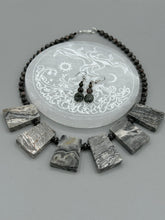 Load image into Gallery viewer, These earrings are crafted with turmaline quartz, snowflake obsidian and black glass beads, creating a neutral cool look that is both unique and adaptable to any style. Measurements: 1 1/2” in length