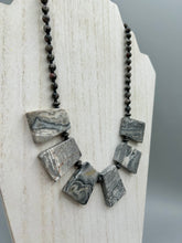 Load image into Gallery viewer, This rustic necklace features an eye-catching large trapezoid-shaped Picasso jasper and black agate combo set in a unique and chic design. Handcrafted from genuine stones, this necklace is perfect for any bohemian look. Measurements: Necklace is 19 1/2"