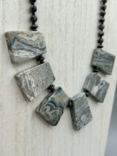 Load image into Gallery viewer, This rustic necklace features an eye-catching large trapezoid-shaped Picasso jasper and black agate combo set in a unique and chic design. Handcrafted from genuine stones, this necklace is perfect for any bohemian look. Measurements: Necklace is 19 1/2"