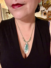 Load image into Gallery viewer, This Dark Green Agate Geode Sliced Stone Chip Necklace is a statement piece for your jewelry collection. It features a bold dark green agate geode pendant surrounded by a green aventurine, gold tone and green glass beaded necklace. The silver leaf bail completes this chic, Boho-inspired necklace.  Measurements:   Necklace is 19” in length - pendant is 2 1/4” Height