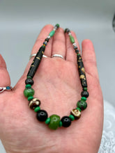 Load image into Gallery viewer, This exquisite necklace features natural ruby zoisite, black obsidian, turquoise magnesite, bone, glass and metal beads, offering a variety of sizes, shapes, textures, and colors. Measurements: Necklace - 20" in length