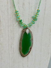 Load image into Gallery viewer, This Dark Green Agate Geode Sliced Stone Chip Necklace is a statement piece for your jewelry collection. It features a bold dark green agate geode pendant surrounded by a green aventurine, gold tone and green glass beaded necklace. The silver leaf bail completes this chic, Boho-inspired necklace.  Measurements:   Necklace is 19” in length - pendant is 2 1/4” Height