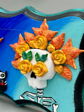Load image into Gallery viewer, La Catrina y Gatita wall art is the purrfect hanging Day of the Dead art piece to add to your ofrenda. A tribute to an unbreakable bond and eternal love between cats and their guardians. Featuring a vibrant and intricate detail catrina and her floral crown accompanied by her beloved kitty cat. This Day of the Dead-inspired artwork adds a little touch of Mexican art to your home or office. A unique handcrafted gift for any cat lover. Measurements: H 5" x W 7” x D 1 1/2"