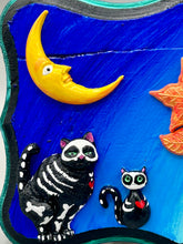 Load image into Gallery viewer, La Catrina y Gatita wall art is the purrfect hanging Day of the Dead art piece to add to your ofrenda. A tribute to an unbreakable bond and eternal love between cats and their guardians. Featuring a vibrant and intricate detail catrina and her floral crown accompanied by her beloved kitty cat. This Day of the Dead-inspired artwork adds a little touch of Mexican art to your home or office. A unique handcrafted gift for any cat lover. Measurements: H 5" x W 7” x D 1 1/2"