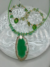 Load image into Gallery viewer, Natural aventurine stone chips, turquoise, and gold glass beads are strung together to form these stylish hoop earrings. The dark green pressed glass leaf charm complements the design, creating an iridescent, shimmery finish with subtle hues of gold, purple, blue, and pink.  Measurements: 2" length