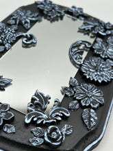 Load image into Gallery viewer, Make a bold statement with this handcrafted Goth Floral Decorative Mirror Wall Art Decor. The wood frame is complimented with highly detailed flowers, leaf and vine motifs, enhanced with shimmery metallic highlights for added texture and depth. Each intricate detail is carefully sculpted to create a unique and beautiful piece that's sure to make a statement. H 6 3/4" x W 9 1/2” x D 1"