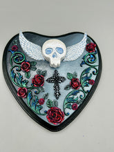Load image into Gallery viewer, This Memento Mori Wall Art Decor is a one-of-a-kind art piece, skillfully crafted with a polymer clay skull and wings on a dark gray hear shape wood frame, decoratively woven with dark red roses and vines. It's perfect for adding an eye-catching touch to any wall and makes a unique, bold gift. W 6 1/2" x H 6 3/4"x D1 1/2"