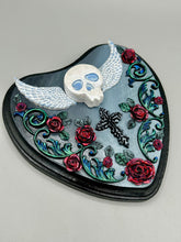Load image into Gallery viewer, This Memento Mori Wall Art Decor is a one-of-a-kind art piece, skillfully crafted with a polymer clay skull and wings on a dark gray hear shape wood frame, decoratively woven with dark red roses and vines. It's perfect for adding an eye-catching touch to any wall and makes a unique, bold gift. W 6 1/2" x H 6 3/4"x D1 1/2"