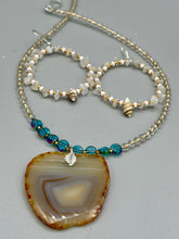 Load image into Gallery viewer, Delicate white moon stone chip and glass beaded hoop earrings featuring chic gold accents and tiny conch shells. Perfect for nature lovers, these boho-inspired summer earrings will add a subtle sophistication to any outfit. Measurements: 2" length