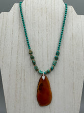 Load image into Gallery viewer, This unique and luxurious Amber Tone Agate Geode Sliced Stone Chip Necklace is a one-of-a-kind statement piece crafted from natural gemstones. The necklace features an amber-tone banded geode, suspended from a strand of blue and green turquoise and gold glass beads, and blue-green magnesite stone beads. This stylish boho-chic accessory is perfect for any casual or formal occasion. Measurements: Necklace is 18” in length - pendant is 2 1/2” Height