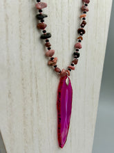 Load image into Gallery viewer, Unlock your inner goddess with this stunning Large Fuchsia Agate Geode Sliced Stone Chip Necklace. Featuring a vibrant fuchsia agate geode pendant surrounded by Rhodonite stone chips and gold and black glass beading, the silver leaf bail completes this chic and boho-inspired look. Make a bold statement with this bohemian-style gemstone necklace. Measurements: Necklace is 17 3/4” in length - pendant is 3” Height