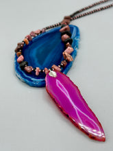 Load image into Gallery viewer, Unlock your inner goddess with this stunning Large Fuchsia Agate Geode Sliced Stone Chip Necklace. Featuring a vibrant fuchsia agate geode pendant surrounded by Rhodonite stone chips and gold and black glass beading, the silver leaf bail completes this chic and boho-inspired look. Make a bold statement with this bohemian-style gemstone necklace. Measurements: Necklace is 17 3/4” in length - pendant is 3” Height