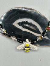Load image into Gallery viewer, This beautiful Bee Pendant With Black and Yellow Beaded Necklace is the perfect accessory for any summer outfit. The vibrant colors will make a bold statement, while the black and gold blend adds a subtle elegance. Its perfect for any nature lover, hippie, or witchy style.  Measurements:  Necklace is 18”