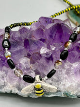 Load image into Gallery viewer, This beautiful Bee Pendant With Black and Yellow Beaded Necklace is the perfect accessory for any summer outfit. The vibrant colors will make a bold statement, while the black and gold blend adds a subtle elegance. Its perfect for any nature lover, hippie, or witchy style.  Measurements:  Necklace is 18”