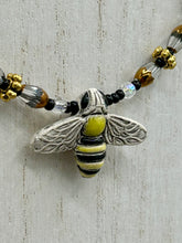 Load image into Gallery viewer, This beautiful Bee Pendant With Black and Yellow Beaded Necklace is the perfect accessory for any summer outfit. The vibrant colors will make a bold statement, while the black and gold blend adds a subtle elegance. Its perfect for any nature lover, hippie, or witchy style.   Measurements:   Necklace is 18”
