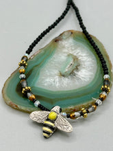 Load image into Gallery viewer, This beautiful Bee Pendant With Black and Yellow Beaded Necklace is the perfect accessory for any summer outfit. The vibrant colors will make a bold statement, while the black and gold blend adds a subtle elegance. Its perfect for any nature lover, hippie, or witchy style.   Measurements:   Necklace is 18”