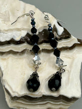 Load image into Gallery viewer, These shimmering black and silver glass beaded earrings feature a large black teardrop glass bead for added movement. This sophisticated and versatile accessory can be worn for an elegant evening look, brunch ensemble, wedding necklace, or minimalist style. Measurements: 2 1/2” in length