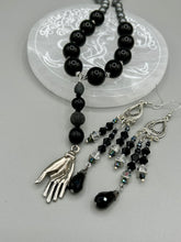 Load image into Gallery viewer, This stylish three-strand black and silver glass beaded earring design presents a beautiful dancing effect, boasting a large black teardrop glass bead. A versatile accessory, it suits a variety of ensembles from cocktail chic to wedding fineries, and its minimalist aesthetic lends a modern charm.  Measurements: 3 3/4” in length