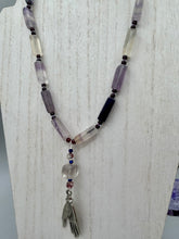 Load image into Gallery viewer, This nature-inspired accessory features an array of unique hues, including rectangular-shaped rainbow fluorite stone beads, round amethyst beads and dark purple glass beads. The secure hook-eye clasp makes it perfect for day to night wear, allowing you to add a touch of summer to your wardrobe. The necklace is further complemented by a large square-shaped rainbow fluorite bead and a lucky hand charm. Measurements: Necklace: 18", Lucky hand pendant 3"