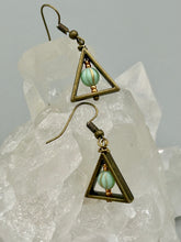 Load image into Gallery viewer, Antique antique brass plated steel ear-wire French Hook Earrings. Antique brass triangle dangle earrings feature a light mint green melon Czech faceted round glass beads with a tint of light gold shimmer. Unique style earrings display a beautiful complimentary tones between the light mint green beads and the warm brass tone. Antique antique brass plated steel ear-wire French Hook Earrings. Measurements: 1" length