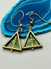 Load image into Gallery viewer, Antique antique brass plated steel ear-wire French Hook Earrings. Antique brass triangle dangle earrings feature a light green round glass beads with tiny small gold tone beads. Unique style earrings display a beautiful complimentary tones between the light green beads and the warm brass tone. Antique antique brass plated steel ear-wire French Hook Earrings. Measurements: 1" length
