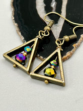 Load image into Gallery viewer, Antique brass triangle dangle earrings feature a purple tone glass bead with an iridescent shimmer finish showcasing hues of gold, purple, blue and pink. Unique style earrings display a beautiful contras between the dark and cool tone glass beads and the warm brass tone. Antique brass plated steel ear-wire French Hook Earrings. Measurements: 1" length