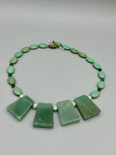 Load image into Gallery viewer, This expertly crafted necklace features a large trapezoid-shaped green aventurine stone, mint green melon beads with gold shimmer, and teal glass beads with an amber tone. Intricately arranged together, this piece offers genuine stones and an elegant bohemian style. Measurements: Necklace is 19"