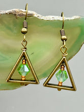 Load image into Gallery viewer, Antique antique brass plated steel ear-wire French Hook Earrings. Antique brass triangle dangle earrings feature a light green round glass beads with tiny small gold tone beads. Unique style earrings display a beautiful complimentary tones between the light green beads and the warm brass tone. Antique antique brass plated steel ear-wire French Hook Earrings. Measurements: 1" length