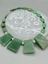 Load image into Gallery viewer, This expertly crafted necklace features a large trapezoid-shaped green aventurine stone, mint green melon beads with gold shimmer, and teal glass beads with an amber tone. Intricately arranged together, this piece offers genuine stones and an elegant bohemian style. Measurements: Necklace is 19"