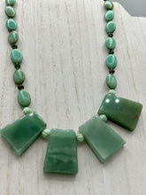 Load image into Gallery viewer, This expertly crafted necklace features a large trapezoid-shaped green aventurine stone, mint green melon beads with gold shimmer, and teal glass beads with an amber tone. Intricately arranged together, this piece offers genuine stones and an elegant bohemian style. Measurements: Necklace is 19"