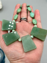 Load image into Gallery viewer, This expertly crafted necklace features a large trapezoid-shaped green aventurine stone, mint green melon beads with gold shimmer, and teal glass beads with an amber tone. Intricately arranged together, this piece offers genuine stones and an elegant bohemian style. Measurements: Necklace is 19"