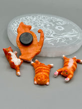 Load image into Gallery viewer, Cat lovers dream, this hand-crafted orange tabby cat magnet art is the purrfect decoration on refrigerators, lockers, cubicles or toolboxes. The set includes three mini cat figurines, featuring emerald green eyes. Measurements: H 2” x W 1/2” x D 3/8” - Cat Magnet H 2” x W 3/8” x D 3/8” - Cat Figurines