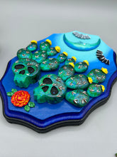 Load image into Gallery viewer, This carefully crafted polymer clay wall art showcases a wood frame adorned with a crescent moon motif. A striking color palette of deep sky tones, including light blue and royal blue to black, further enhances the piece. Delicate cacti plants bloom with light yellow flowers, with spooky skulls are incorporated among the cacti plant and a finishing touch of flying bat motifs. Measurements: H 9" x W 6 1/2” x D 1 1/4"