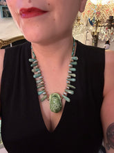 Load image into Gallery viewer, This powerful statement piece necklace features an eye-catching hand sculpted dark blue clay scarab beetle pendant. Adorned with green magnesite and serpentine teintee stone beaded necklace, this dramatic necklace artfully wraps around the neck, conveying an elegant and bold style. Necklace is 20 1/4" in length